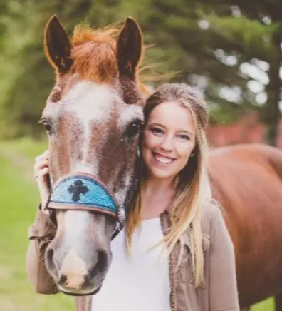 Cassie posing next to a horse